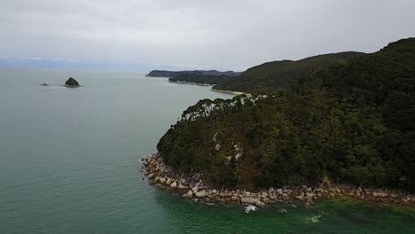 Vista-Aérea-Volando-Sobre-La-Playa-De-Arena-Dorada-Y-Hermosas-Montañas-Verdes-En-El-Parque-Nacional-Abel-Tasman,-Nelson,-Nueva-Zelanda