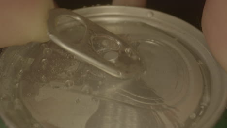 toma macro de la tapa de la lata de refresco que se abre en cámara lenta y burbujeante