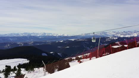 cable cars glide up and down the ropeway taking skiers to the top of a ski piste in the snow capped mountains of the alps