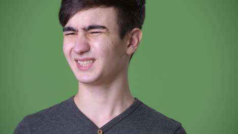 초록색 배경에 젊은 잘생긴 이란 십대 소년