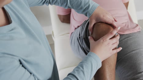 caucasian female physiotherapist checking knee of senior woman, copy space, slow motion