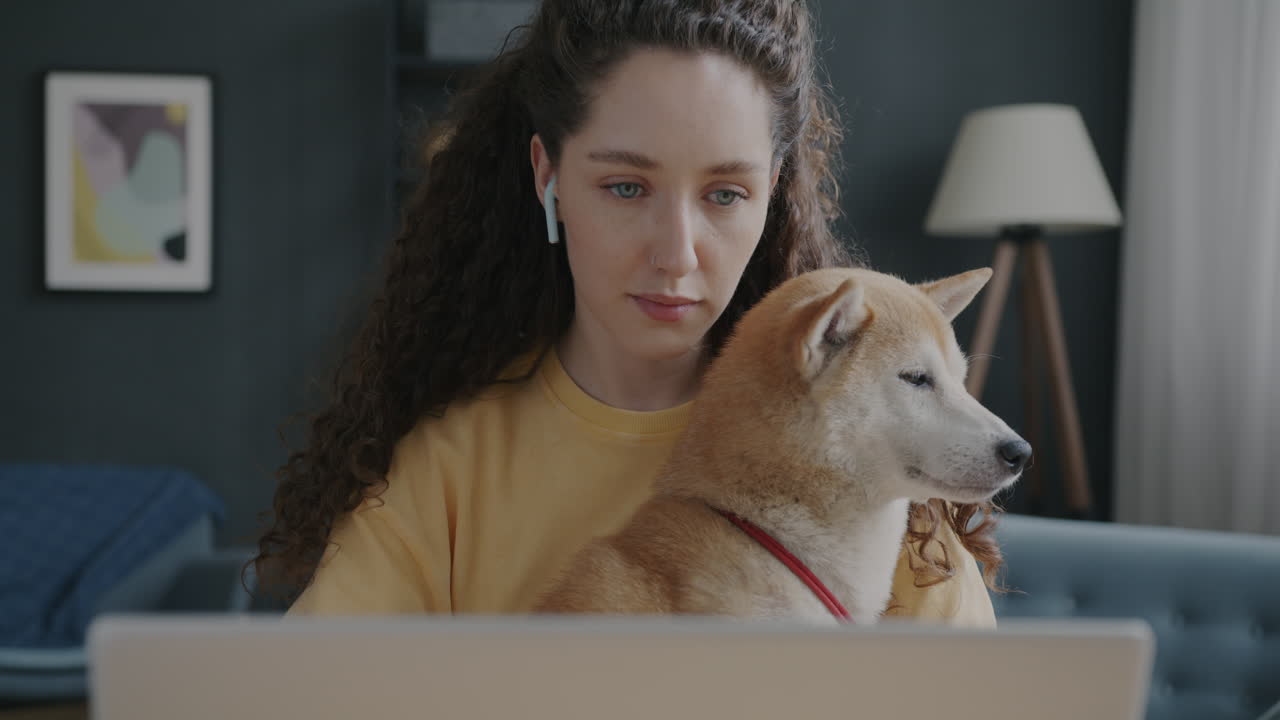 mujer trabajando desde casa con su perro