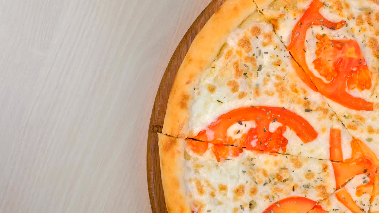 나무판 위에 토마토와 치즈로 피자를 잘라내는 4분의 1