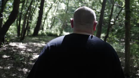 a man walking through forest trees