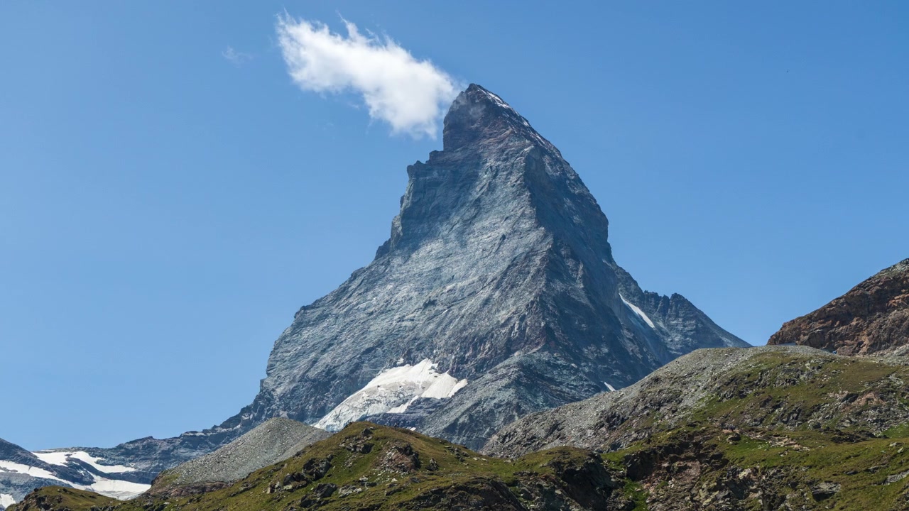 Atmosphärischer Zeitraffer mit dem ikonischen Matterhorn und einer einsamen Wolke in den Schweizer Alpen.