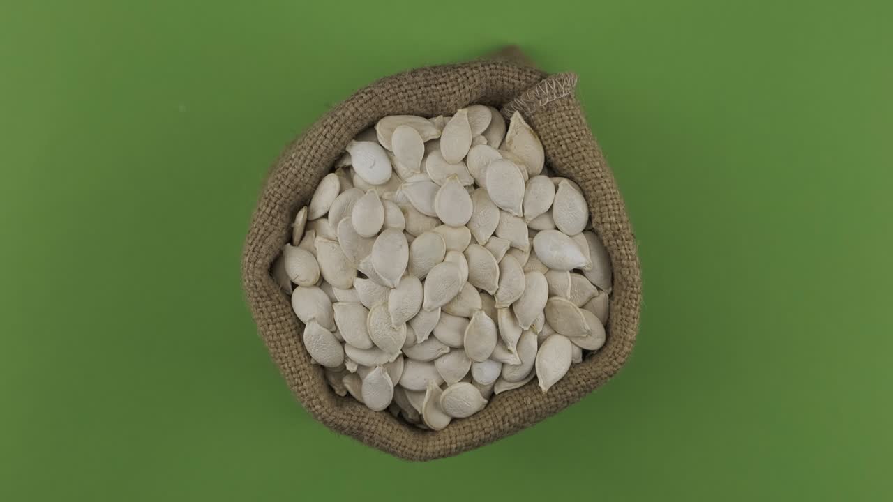 Rotation of a full sack of pumpkin grain. Top view. Isolated