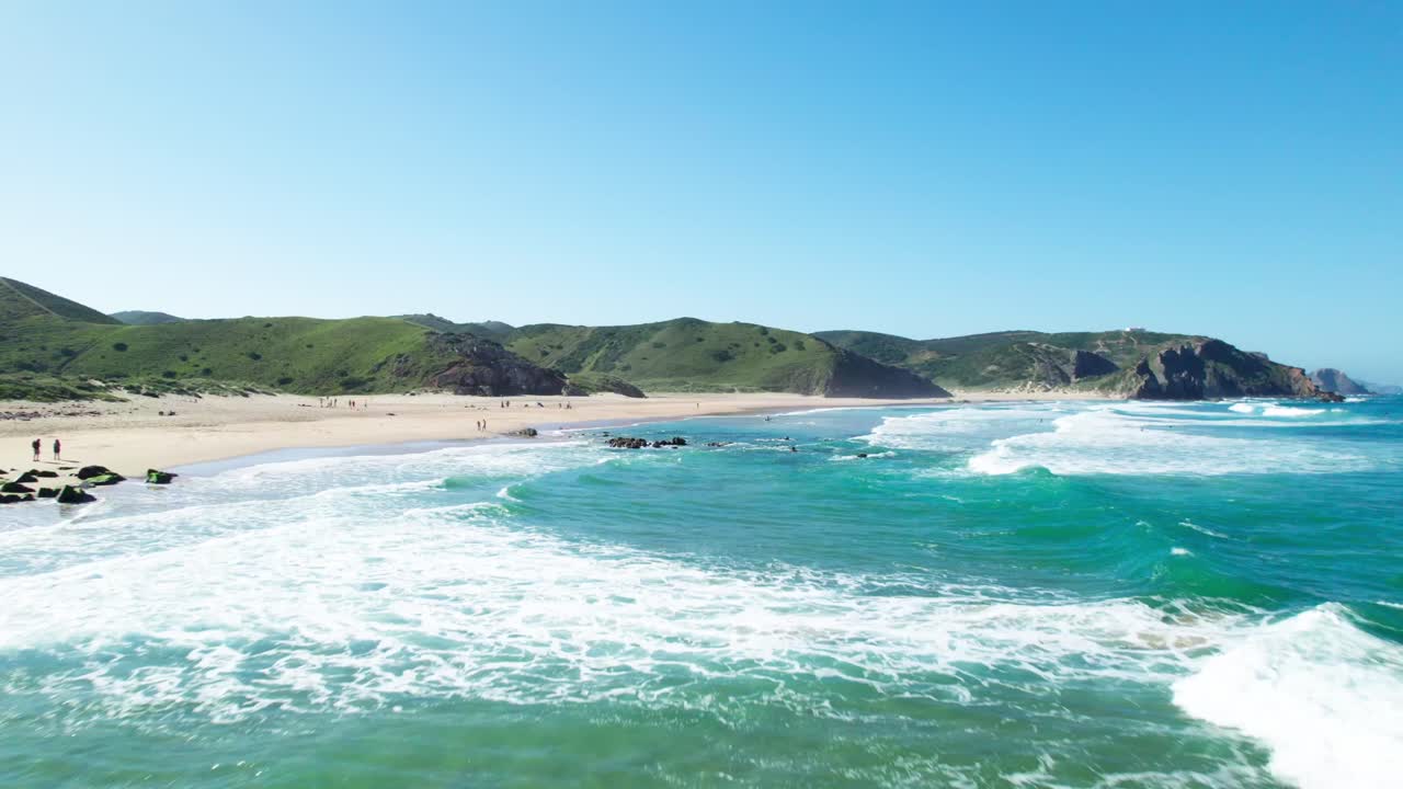 Onde impetuose che si infrangono sulle scogliere e sulla spiaggia di giorno. - Ripresa aerea.