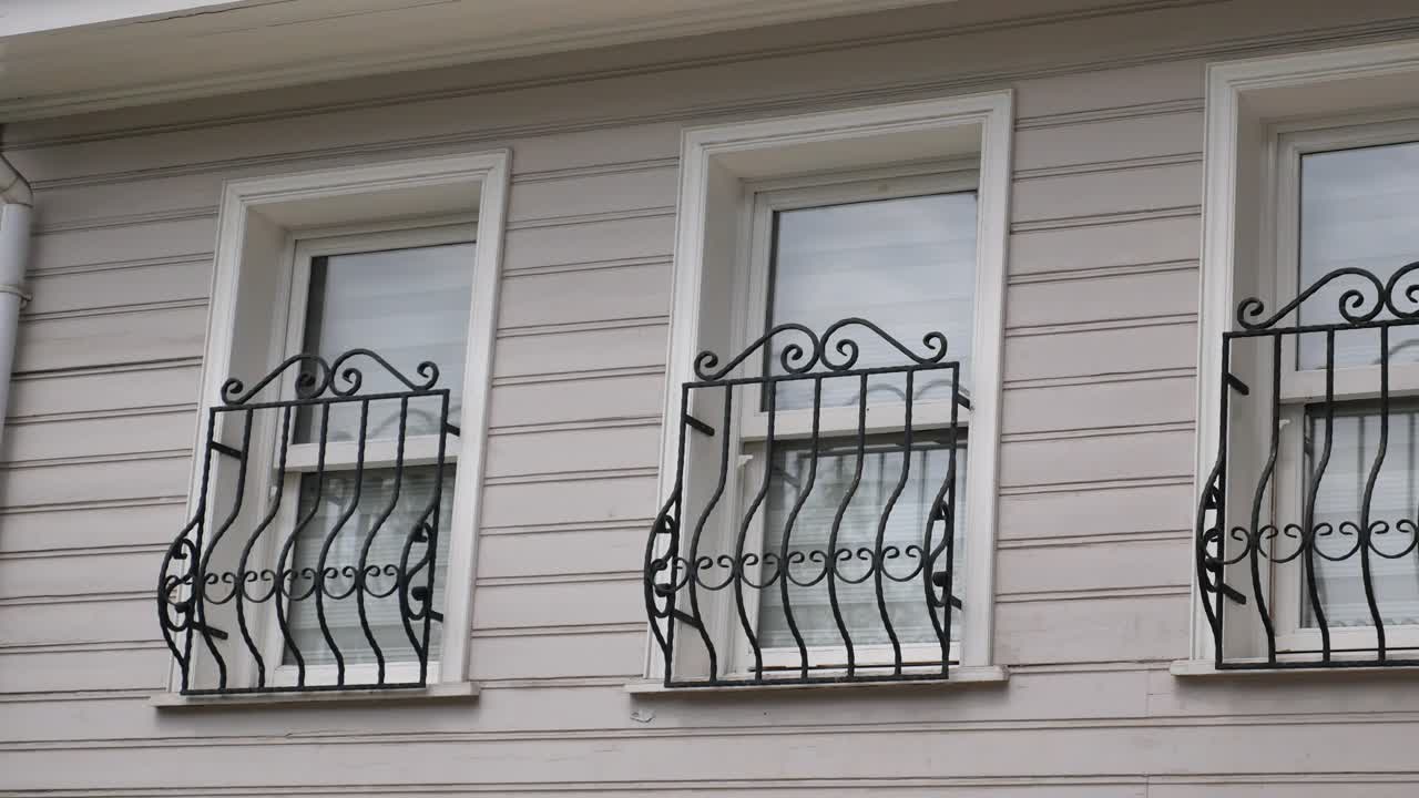 fachada del edificio con balcones de ventanas metálicas ornamentadas