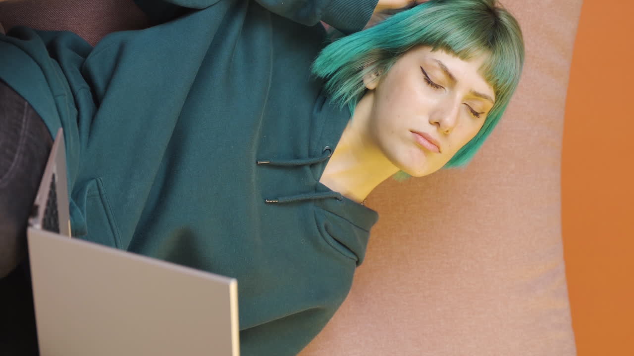 Lodret video af træt ung kvinde ved bærbar computer