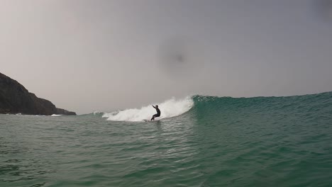 impresionante surfista masculino monta una hermosa ola de barril esmeralda en un día perfecto para surfear en un día soleado