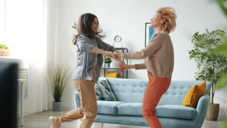 madre e hija bailando en casa