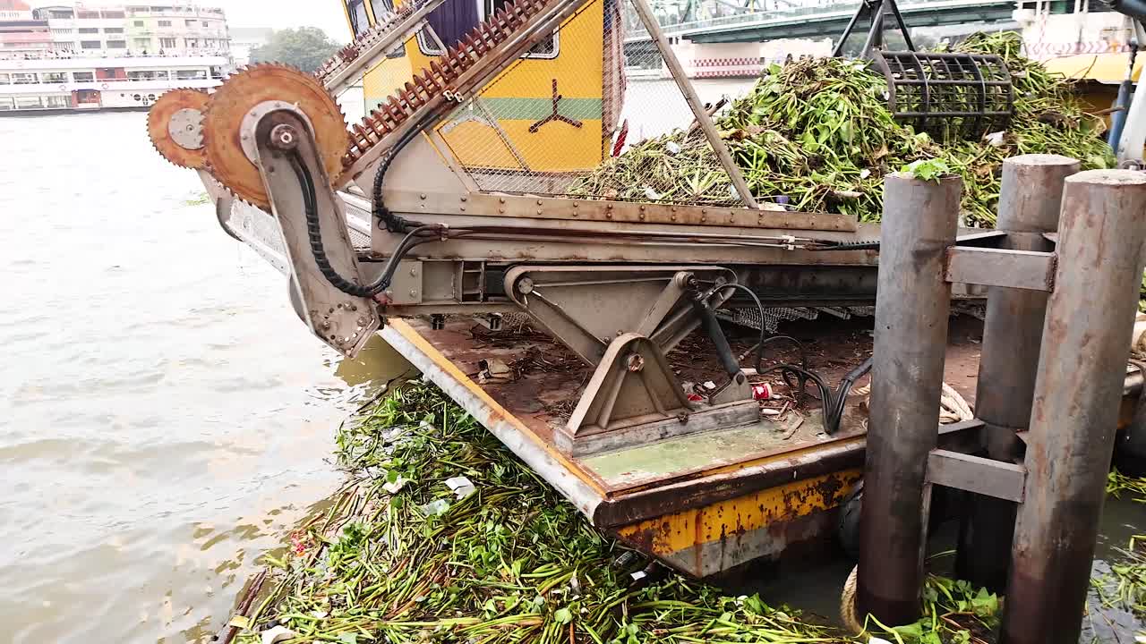 Barca che rimuove detriti dal fiume di Bangkok.