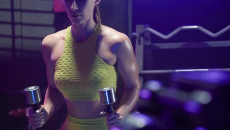 mujer trabajando con pesas en un gimnasio