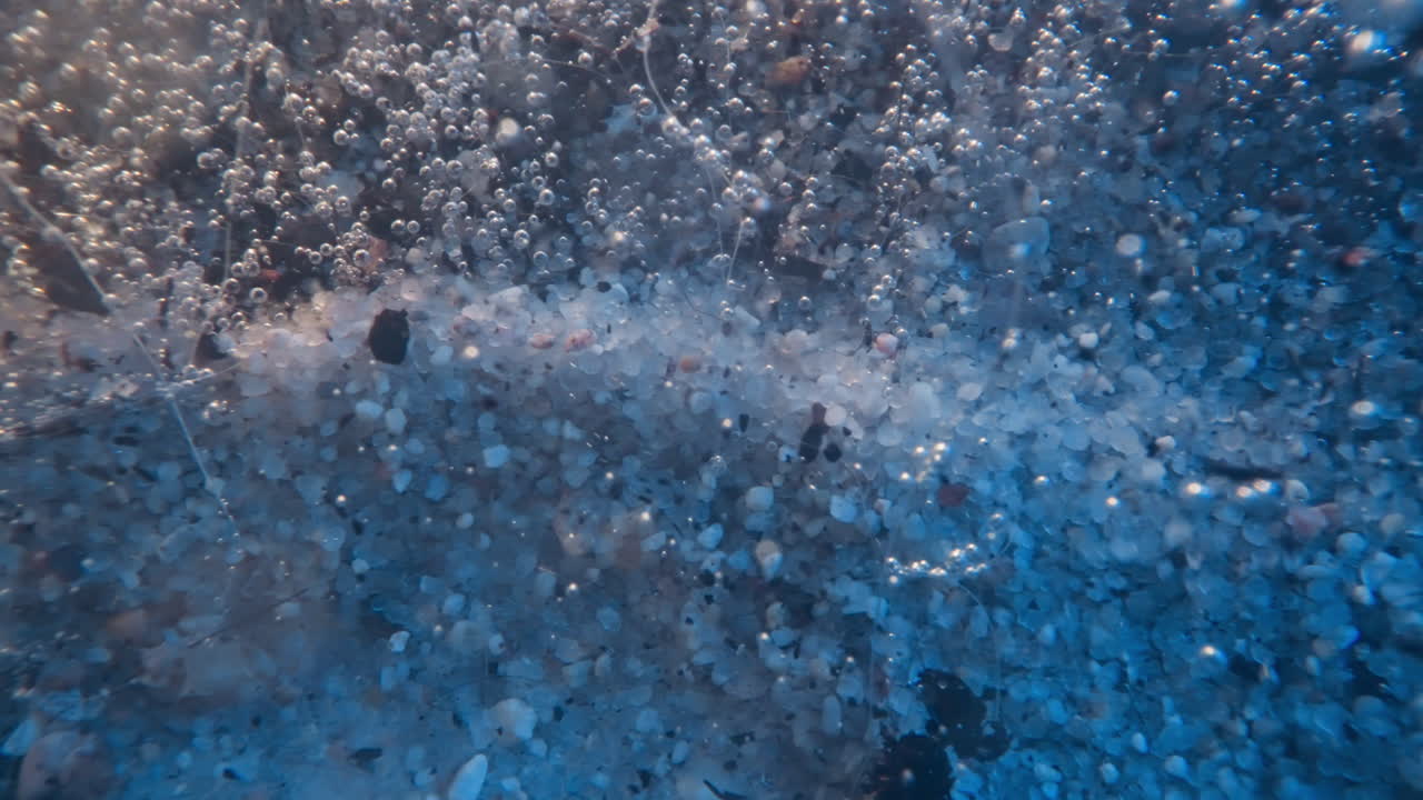 быстрый поток воды несет кусочки грязи и небольшие пузырьки воздуха