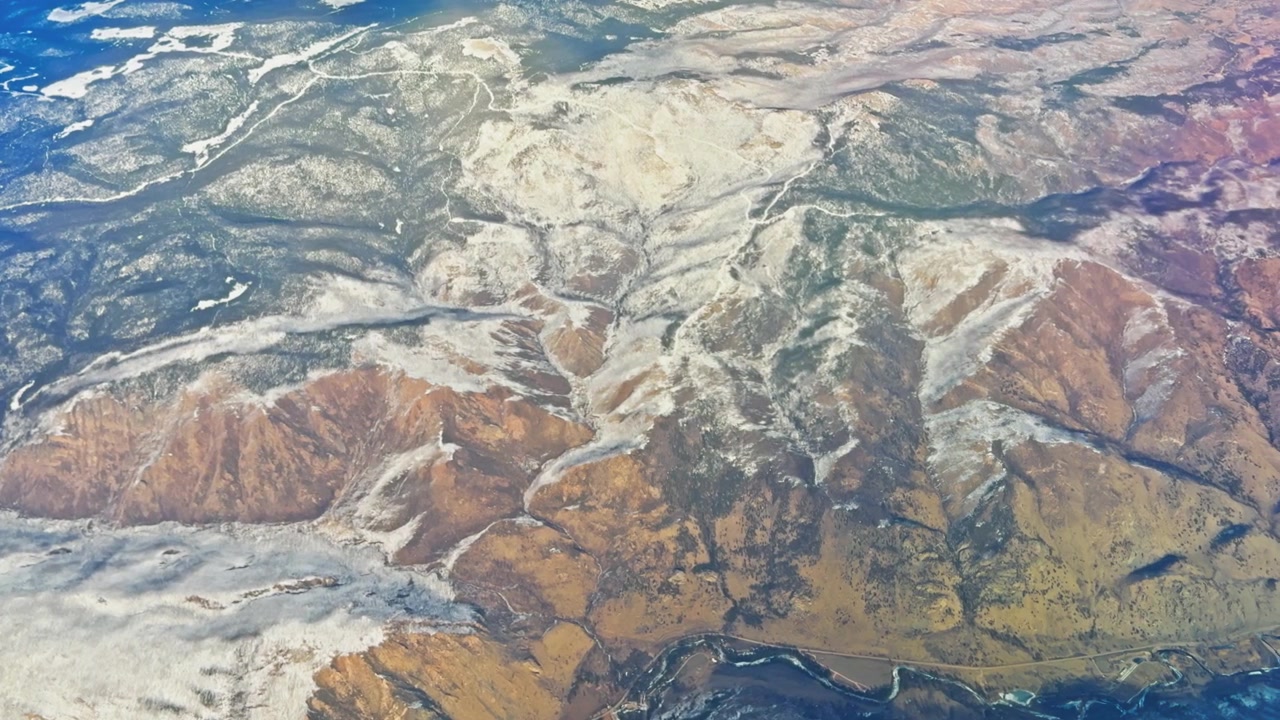 雪化粧した山々が劇的な浸食パターンと険しい地形を現す空撮映像