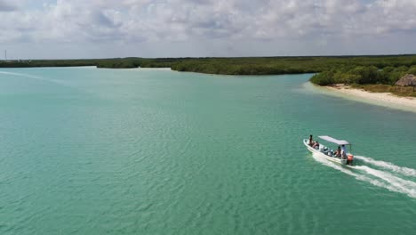 video de vista aérea tomado por un dron de un barco que navega en una playa de arena tropical caribeña con agua turquesa - zafiro, laguna de río lagartos, méxico