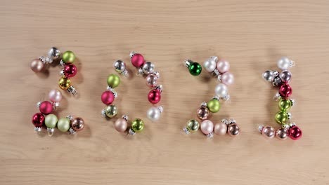 new year twenty twenty one written with christmas balls, sharp to out of focus