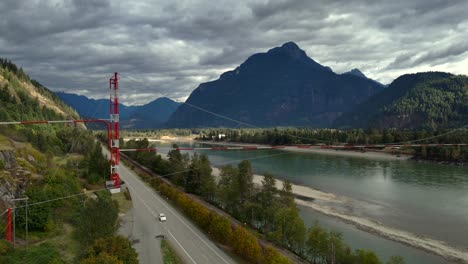 Aerial-Spotlight-on-the-Iconic-Pipeline-Bridge,-Fraser-River,-and-Timbered-Mountains-near-Hope,-BC
