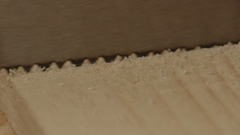 macro view of saw sawing into board of wood