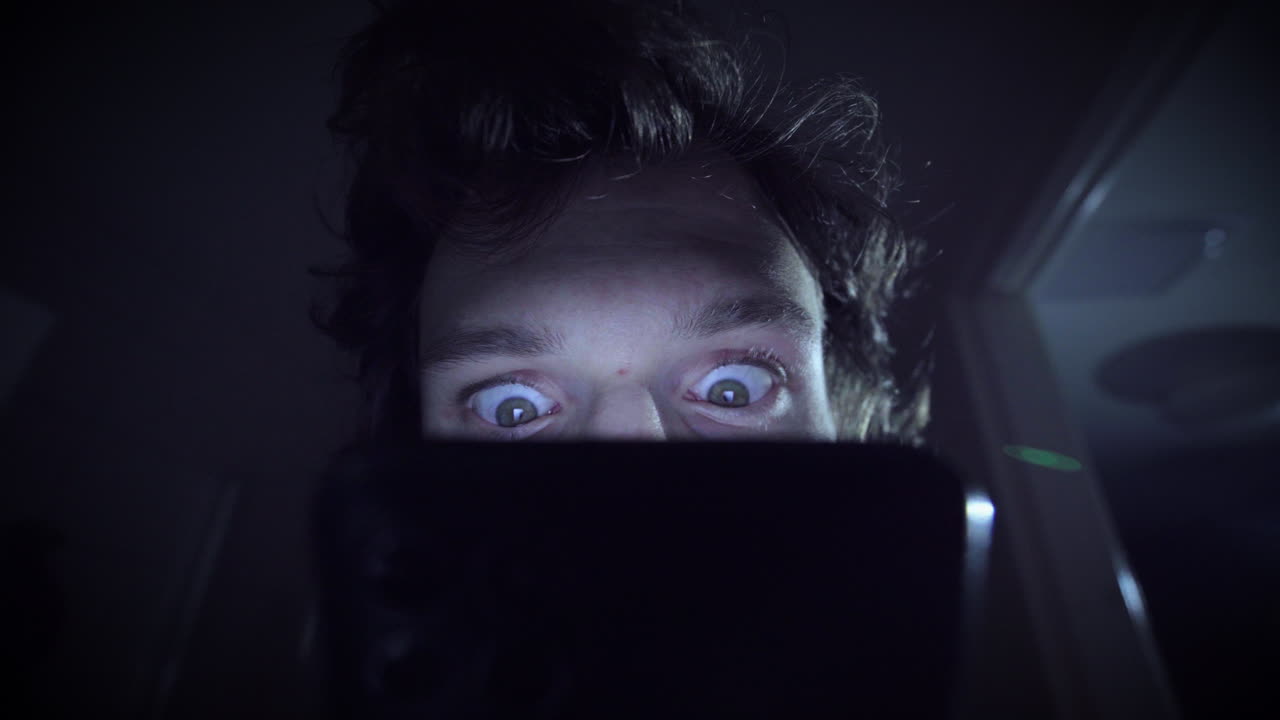 hombre obsesionado con desplazarse en un ambiente oscuro