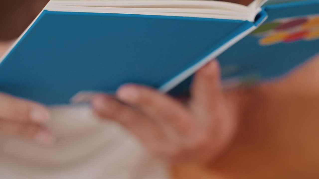 La calma luce ambientale enfatizza il delicato atto di sfogliare le pagine con grazia. La morbida illuminazione mattutina sottolinea il movimento sereno e gentile di sfogliare le pagine in un ambiente pacifico.