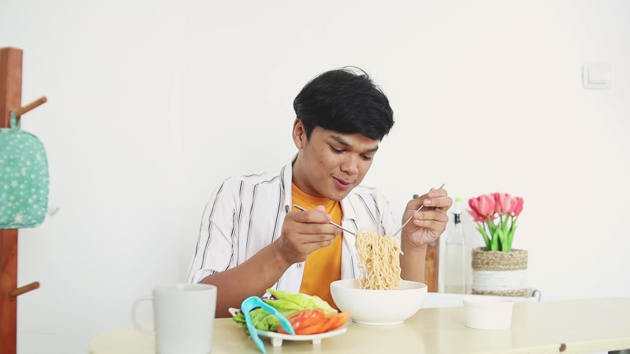 Young Man Enjoying a Delicious Noodle Soup Meal