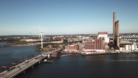 Aerial-view-of-a-windmill-and-a-factory-and-a-big-bridge-near-the-Mystic-River-in-Everett,-Massachusetts