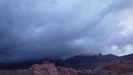 gimbal panning shot across thick dramatic clouds in red rock canyon, las vegas in low light