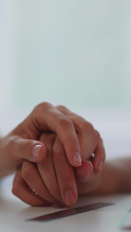 lesbian women in love hold hands while studying together on blurred background. lgbt couple shows feelings sitting at table closeup