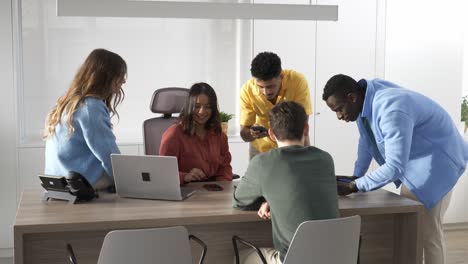 startup team discussing a project on a laptop