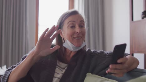 woman having a video chat on her smartphone at home