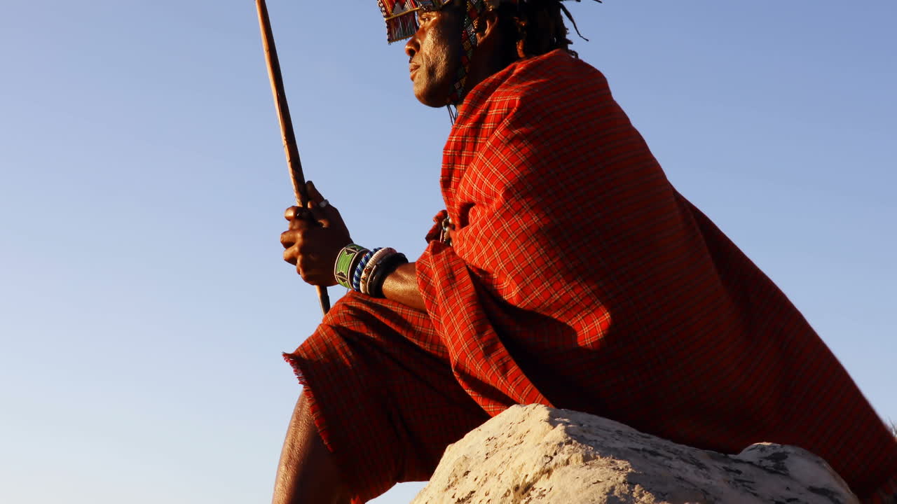 4k의 바위 위에서 휴식을 취하는 부족 남자