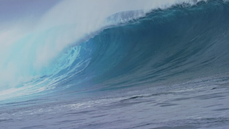 Tracking slow motion view of Cloudbreak Fiji wave crashing with whitewash and mist rising off top