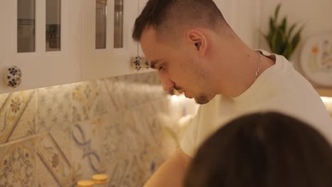 una pareja enamorada haciendo un sándwich en la cocina de la sala de estar
