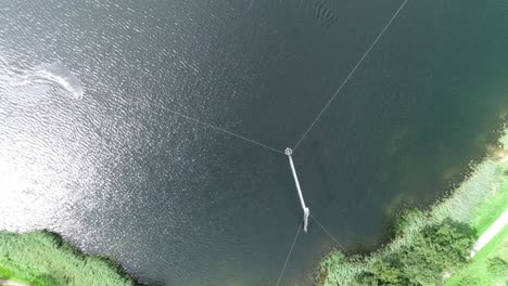 aerial drone shot of a person wakeboarding on lake