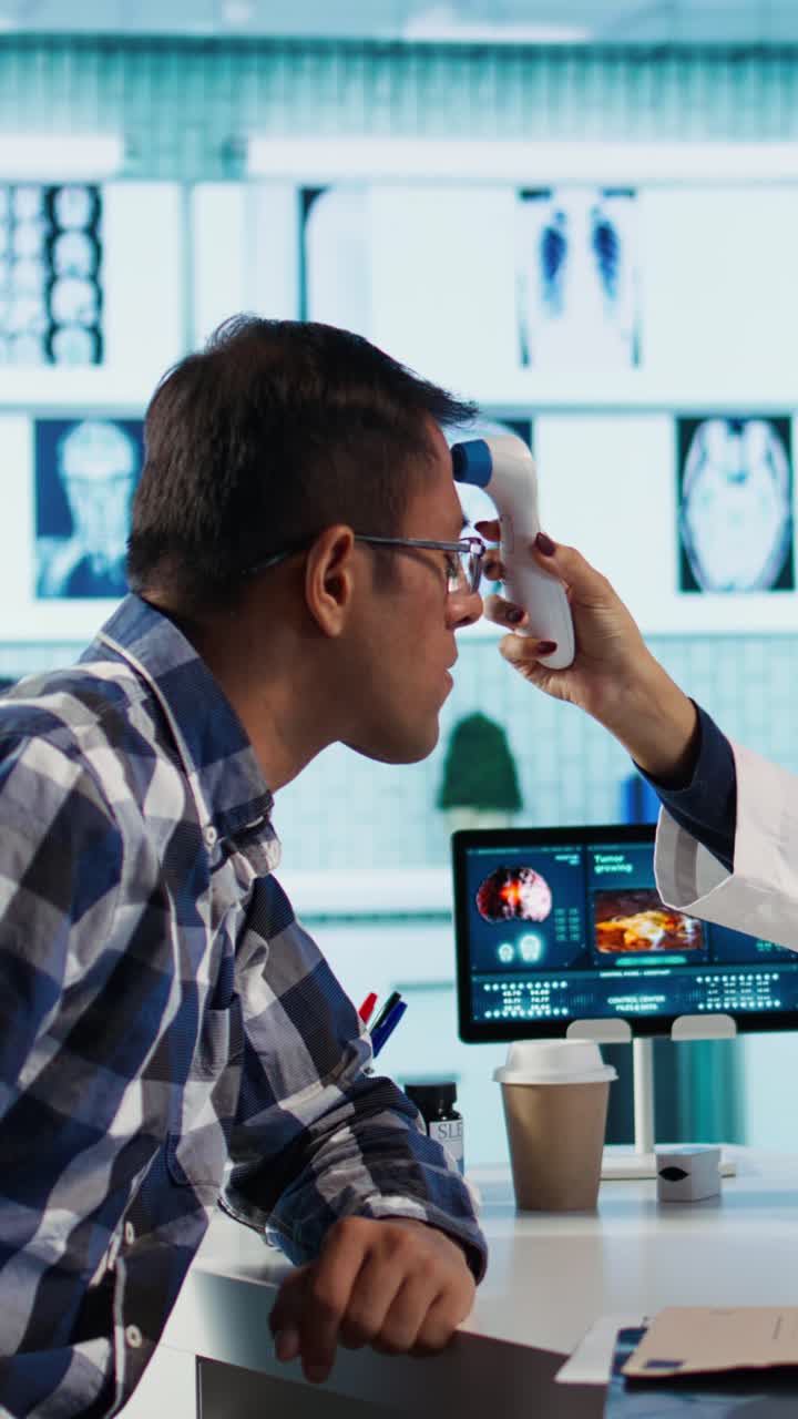 Doctor Checking Patient's Temperature with Digital Thermometer in Clinic