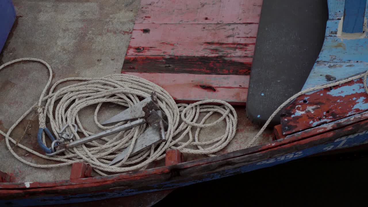 A close up shot of a modern metal anchor and rope place at the bow of a traditional Thai fishing boat, Khao Takiab, Hua Hin, Thailand