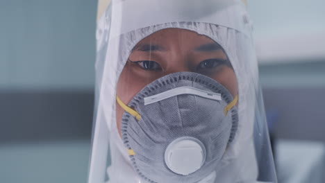 asian doctor taking off mask closeup portrait shot footage of cheerful asian female medical worker taking off protective mask smiling at camera