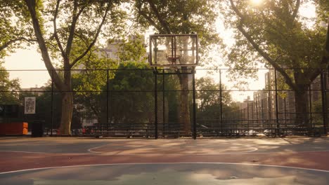 backwards shot on empty basketball court in new york city near central park at sunset