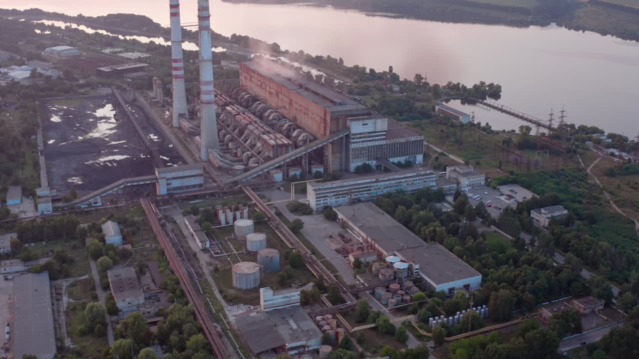 Site with high-voltage lines on the background of the road and trees at sunset. Camera motion forward. Aerial view