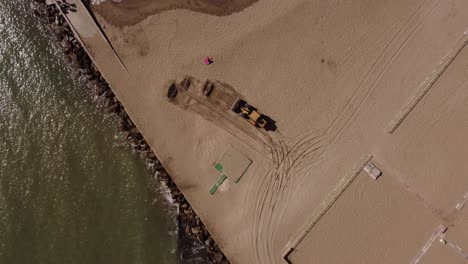 excavator picking sand from beach, mar del plata in argentina