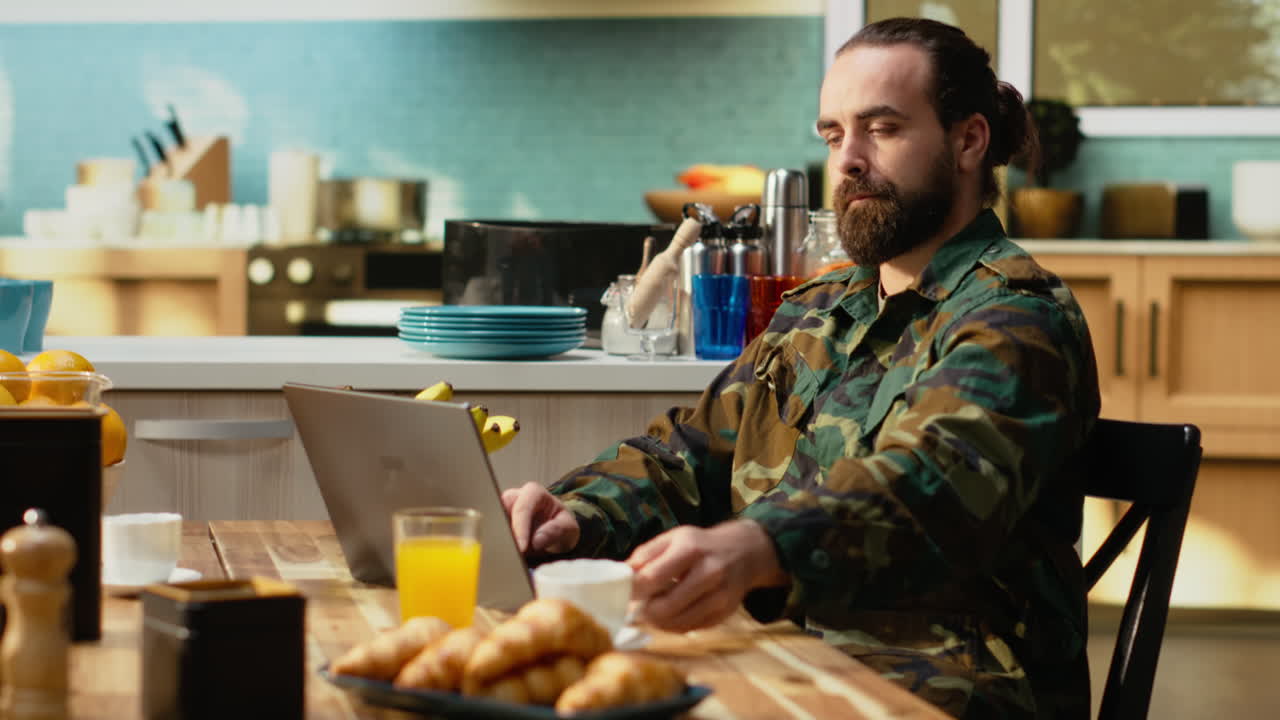Soldat i militæruniform tilbringer en stille morgen i køkkenet