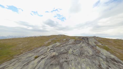 Luftfpv-Flug-über-Die-Bergspitze-Des-Rossnos-Berges-Mit-Epischer-Aussicht-An-Bewölkten-Tagen---Trekking-T-Schilder-Auf-Felsen,-Wegweiser-Für-Wanderung