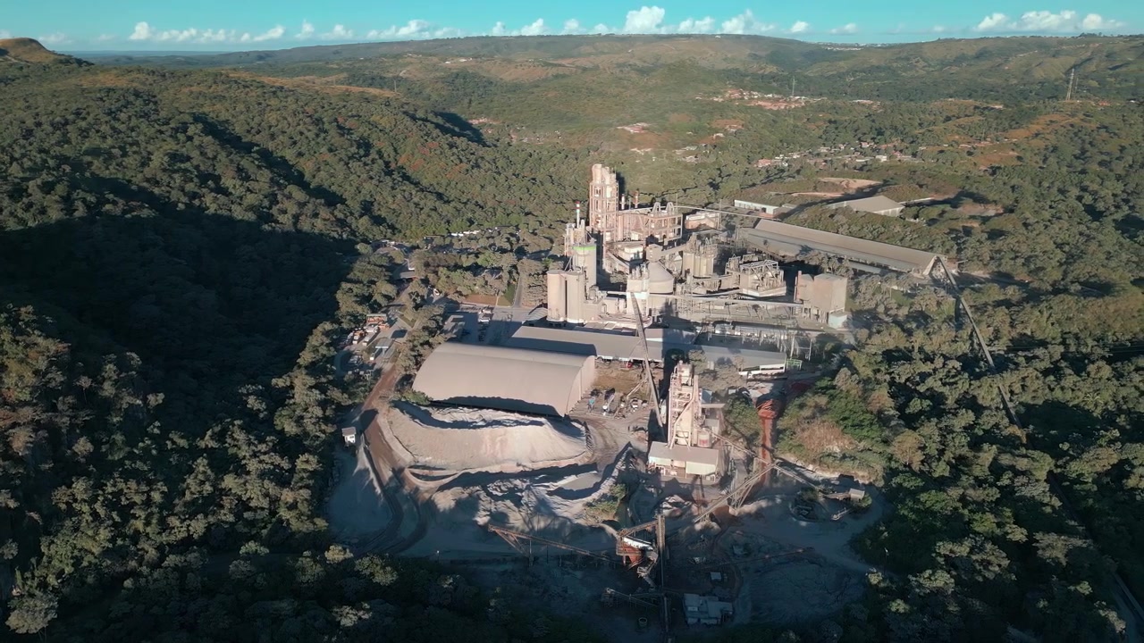 Complejo minero industrial cerca de Brasilia, Distrito Federal, Brasil, toma aérea sobre la excavación de una cantera, planta de procesamiento de minerales, infraestructura de cemento y el paisaje circundante de las tierras altas del Cerrado