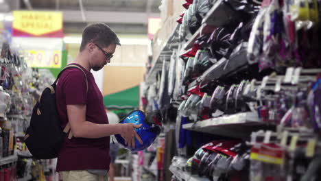 hombre comprando un casco en una tienda