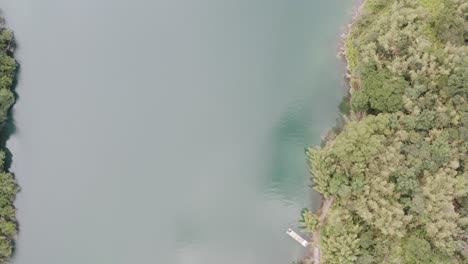 Ascending-tilting-camera-view-of-Spectacular-View-of-Feitsui-Reservoir,-Emerald-lake,-Thousand-Island-Lake-is-Second-largest-water-reservoir-dam-water-supply-in-Taiwan,-leading-to-mountainous-view