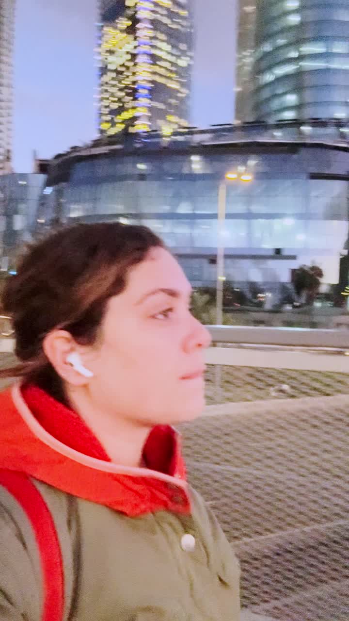 Donna giovane adulta che osserva lo skyline della città di sera