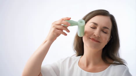 woman enjoying facial massage with a jade roller for skincare