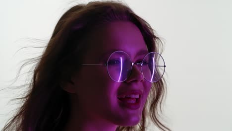 Young Woman in Purple Neon Light with Glasses