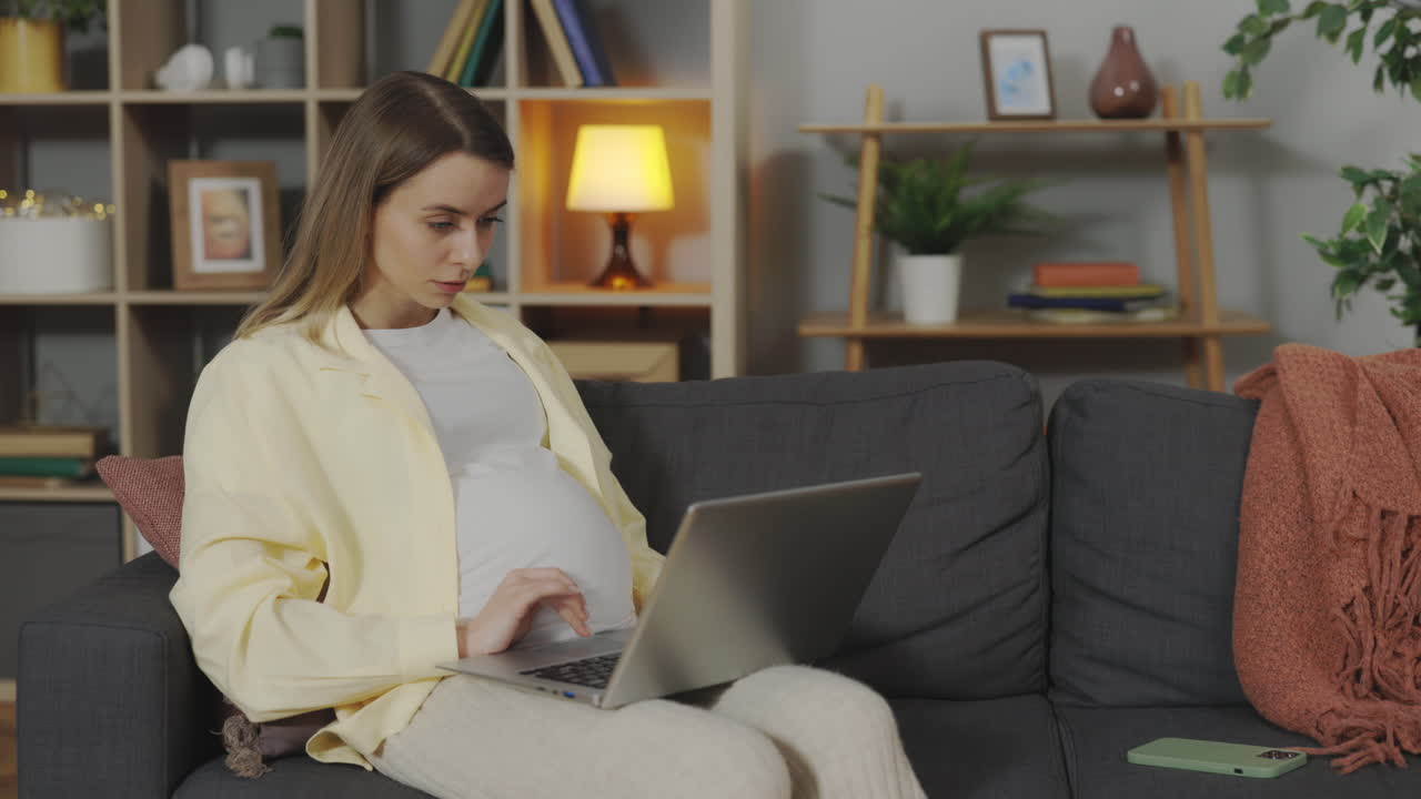 Pregnant woman working from home on laptop